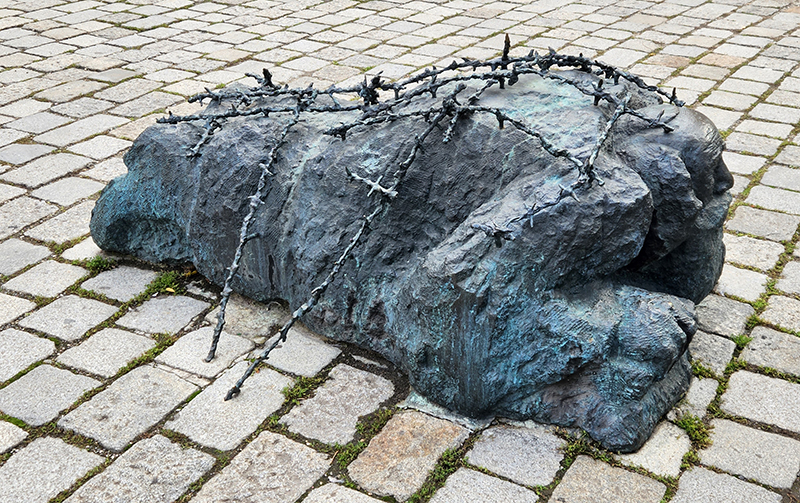 The bronze sculpture of an elderly Jewish man forced to clean a street of anti-fascist propaganda